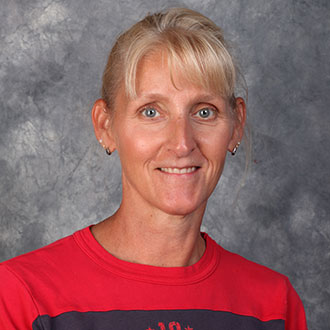 Jackie Lemmermann, Housekeeping Technician for the Housekeeping Department, smiles in front of a gray backdrop.