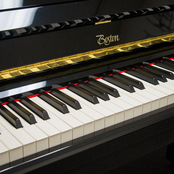 Piano keys with brand name of Boston.