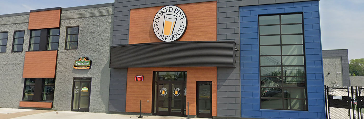 Exterior of Crooked Pint Ale House with a mix of gray brick, wood paneling, and large windows.